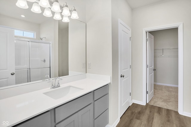 bathroom featuring vanity, an enclosed shower, and wood-type flooring