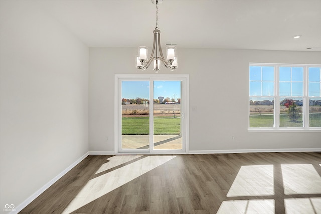 unfurnished dining area with dark hardwood / wood-style flooring and a chandelier