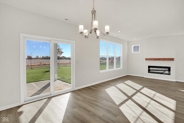 unfurnished dining area featuring hardwood / wood-style flooring and a chandelier