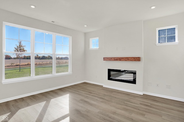 unfurnished living room with wood-type flooring and plenty of natural light