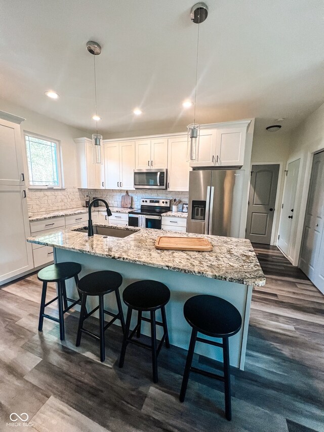 kitchen featuring dark hardwood / wood-style flooring, sink, decorative light fixtures, and appliances with stainless steel finishes