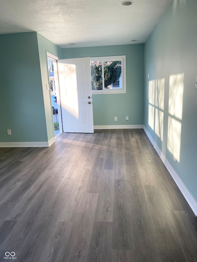 interior space with dark wood-type flooring and a textured ceiling