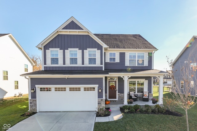 craftsman inspired home featuring a garage and a front lawn