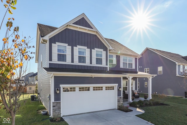 view of front of property featuring a garage, cooling unit, and a front yard