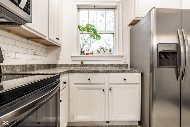 kitchen featuring white cabinets, dark countertops, decorative backsplash, and stainless steel appliances