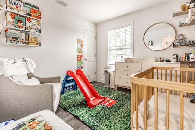 bedroom with a crib and visible vents