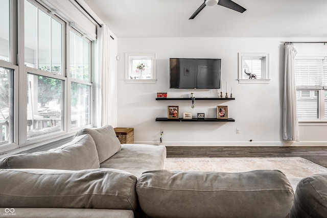 living room with ceiling fan, baseboards, and wood finished floors