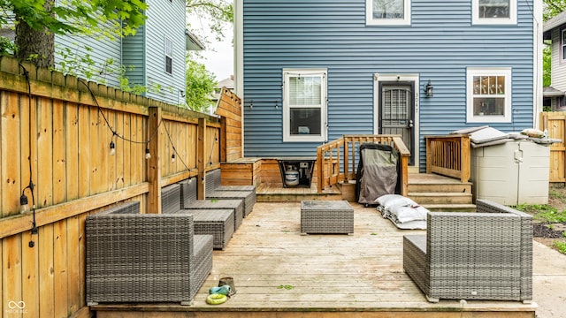 wooden terrace featuring fence and an outdoor living space