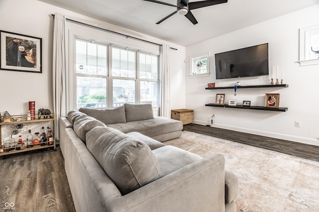 living room featuring baseboards, ceiling fan, and wood finished floors