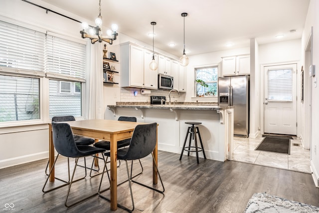 dining area featuring baseboards, a notable chandelier, recessed lighting, and wood finished floors
