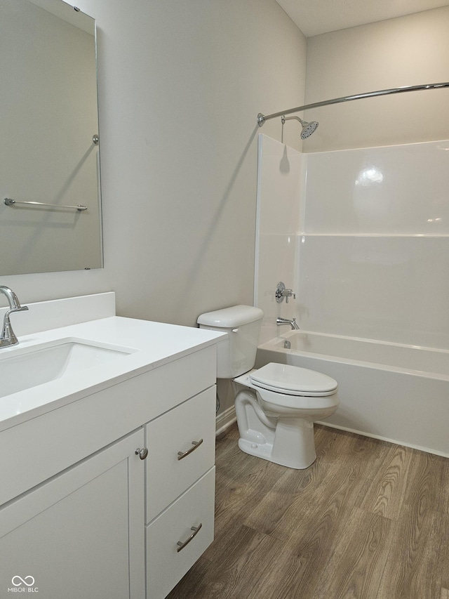 full bathroom featuring  shower combination, hardwood / wood-style flooring, vanity, and toilet