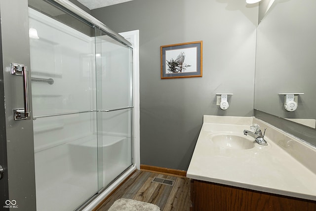 bathroom featuring hardwood / wood-style floors, vanity, and an enclosed shower