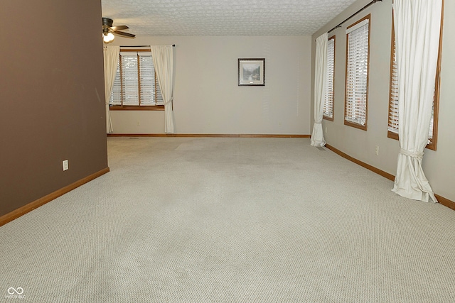 unfurnished bedroom with ceiling fan, light colored carpet, and a textured ceiling