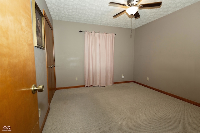 carpeted empty room featuring a textured ceiling and ceiling fan