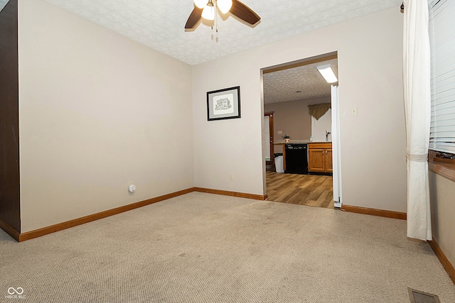 carpeted spare room featuring a textured ceiling and ceiling fan