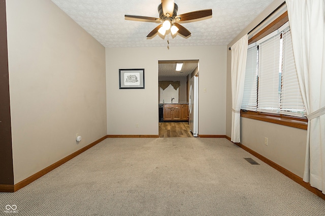 carpeted empty room with a textured ceiling and ceiling fan