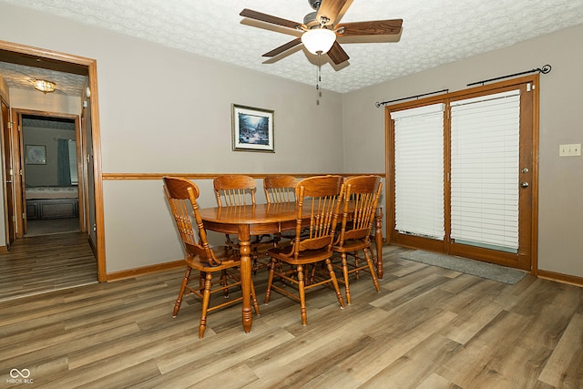 dining space with a textured ceiling, light hardwood / wood-style flooring, and ceiling fan