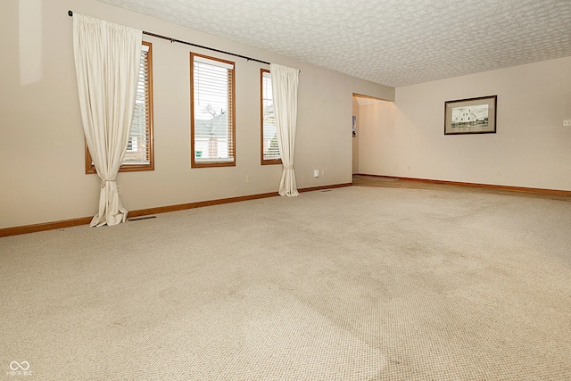 carpeted spare room with a textured ceiling