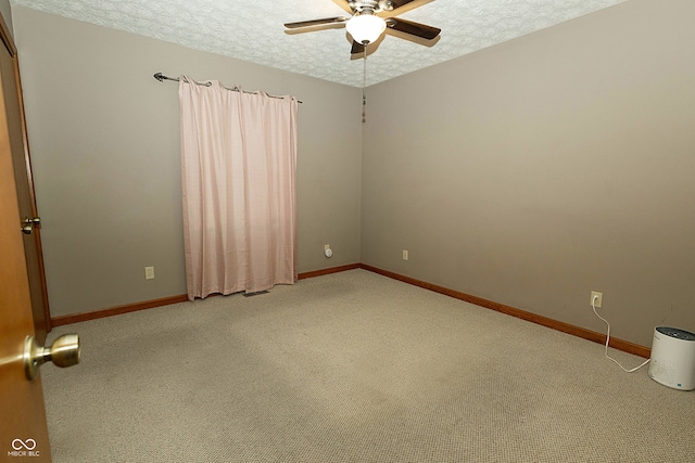 carpeted spare room featuring ceiling fan and a textured ceiling