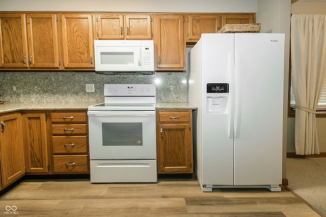 kitchen with white appliances, light hardwood / wood-style floors, and tasteful backsplash