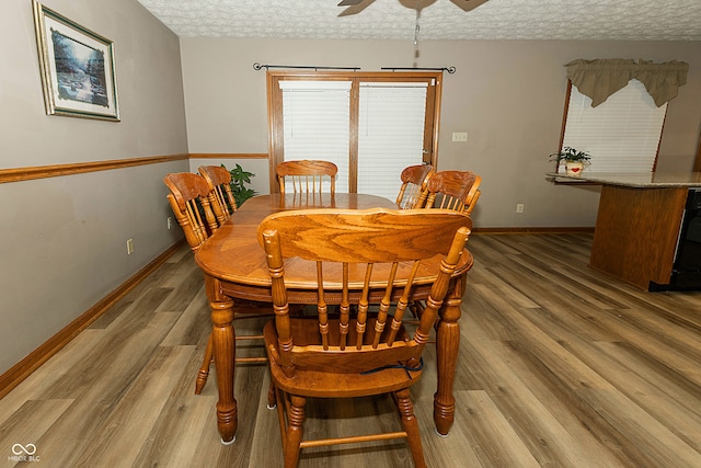 dining room featuring ceiling fan, a textured ceiling, and hardwood / wood-style flooring