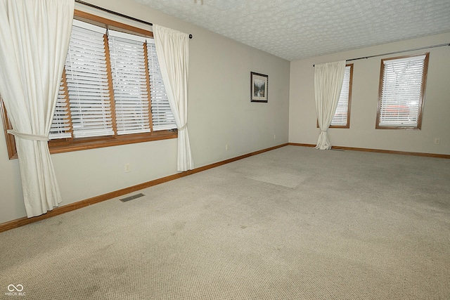 carpeted empty room featuring a textured ceiling