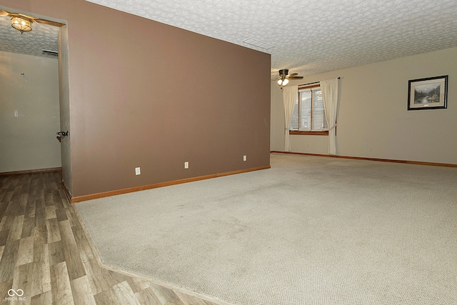 spare room with ceiling fan, wood-type flooring, and a textured ceiling