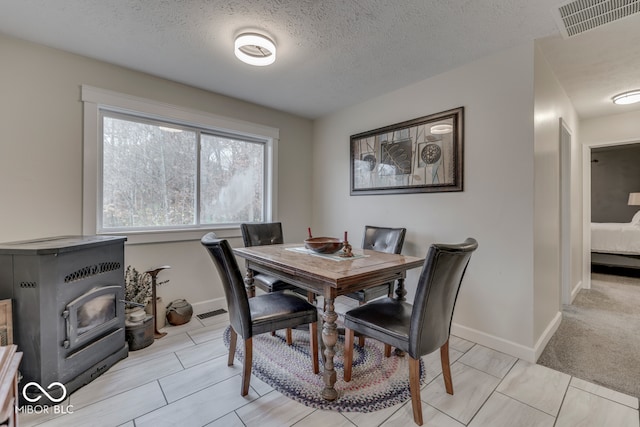 carpeted dining space with a textured ceiling