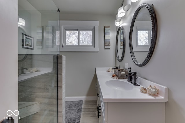 bathroom with hardwood / wood-style floors, a wealth of natural light, vanity, and a shower with shower door