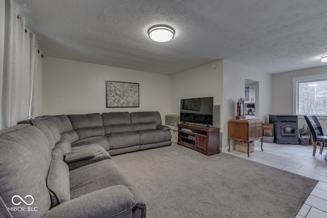 carpeted living room with a textured ceiling and a wood stove