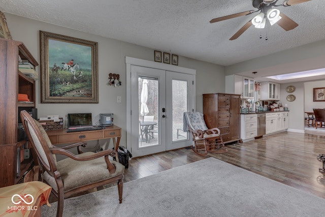 entrance foyer with ceiling fan, wood-type flooring, a textured ceiling, and french doors