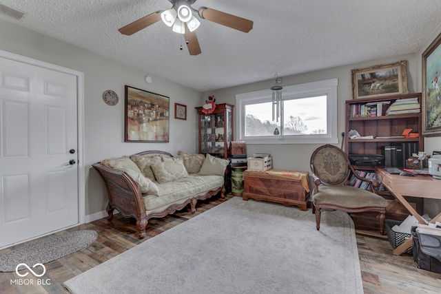 interior space with a textured ceiling, hardwood / wood-style flooring, and ceiling fan