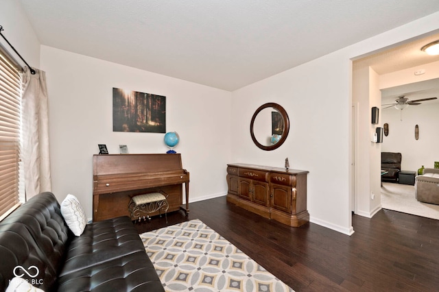 living area with dark hardwood / wood-style flooring and ceiling fan