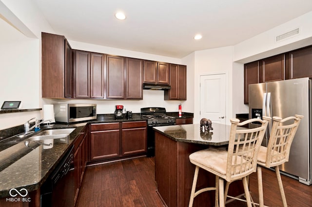 kitchen with black appliances, dark wood-type flooring, dark stone counters, and sink