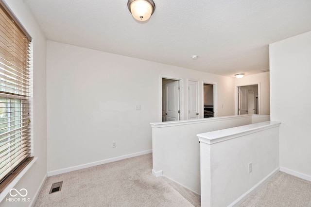 unfurnished room with light colored carpet