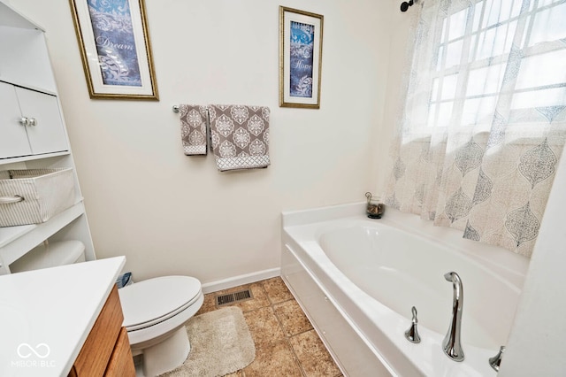 bathroom featuring a tub, vanity, and toilet