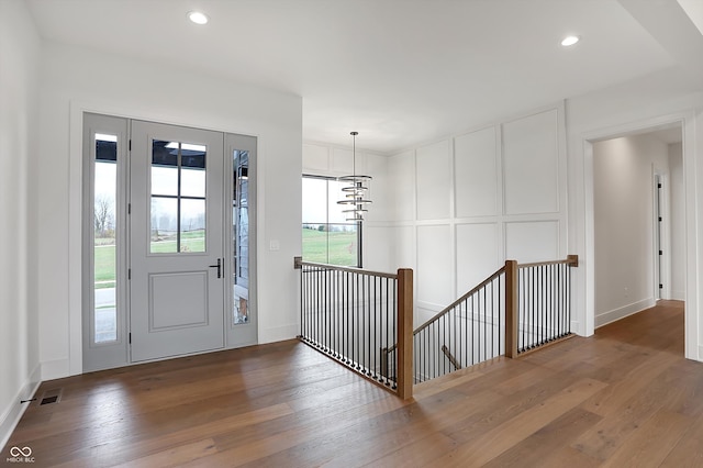 entryway with wood-type flooring and a notable chandelier