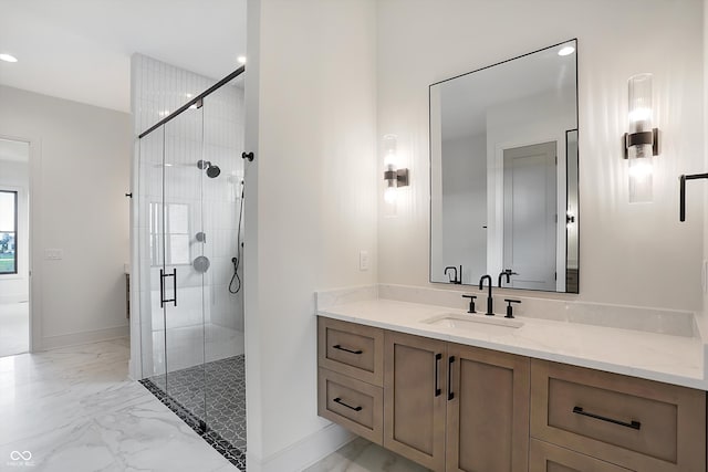 bathroom featuring a shower with door and vanity