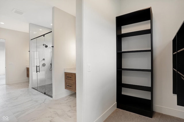 bathroom featuring a shower with door and vanity