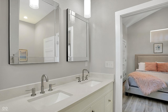 bathroom with vanity, vaulted ceiling, and hardwood / wood-style flooring