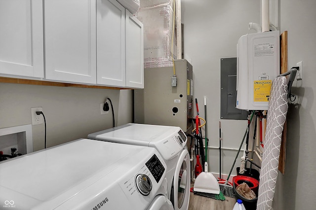 clothes washing area with cabinets, water heater, wood-type flooring, separate washer and dryer, and electric panel