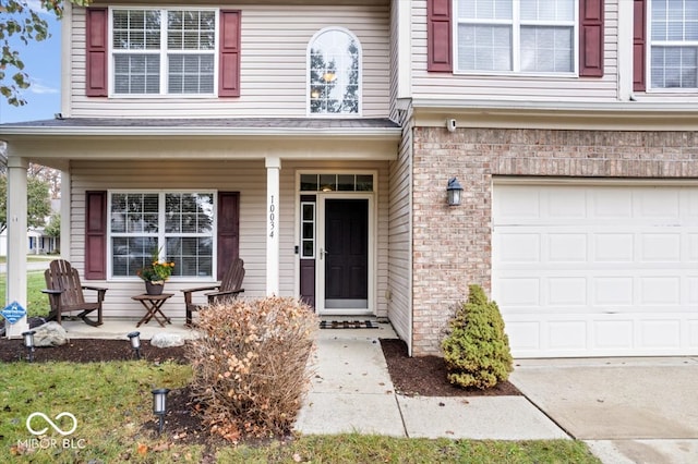 doorway to property featuring a garage and covered porch