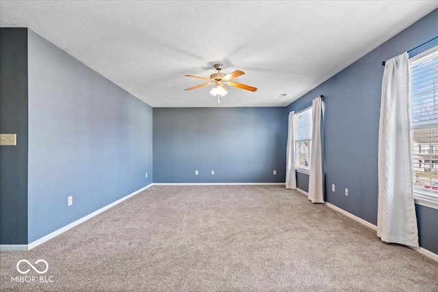 carpeted empty room with ceiling fan and a textured ceiling