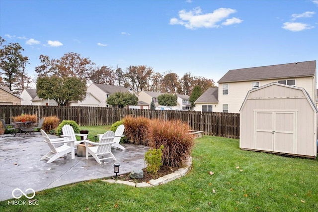 view of yard with a storage shed, a fire pit, and a patio area