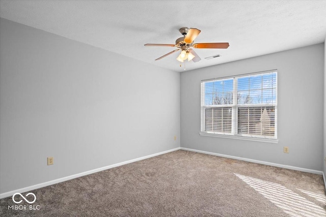 carpeted spare room featuring a textured ceiling and ceiling fan