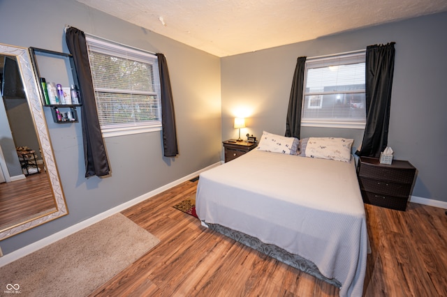 bedroom featuring dark hardwood / wood-style floors and a textured ceiling