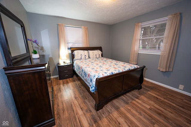 bedroom featuring dark wood-type flooring and a textured ceiling