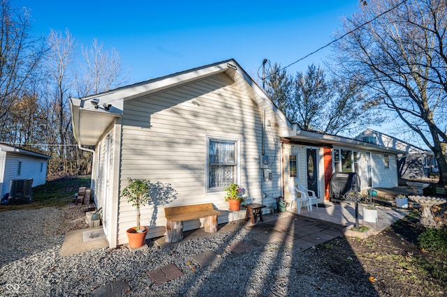 rear view of property with central air condition unit and a patio