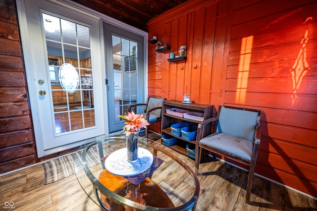 living area featuring hardwood / wood-style floors, wooden walls, and wood ceiling