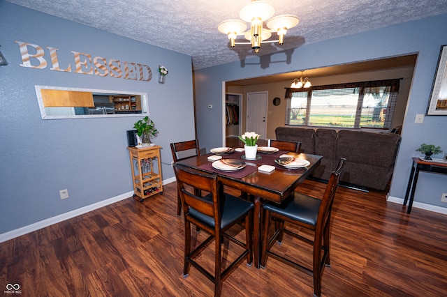 dining room with dark hardwood / wood-style floors, a textured ceiling, and a notable chandelier